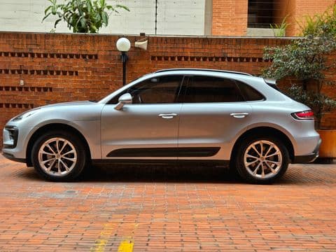 Porsche MACAN 2023 usado vista lateral color plata en garaje Bogotá