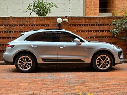 Porsche MACAN 2023 usado vista lateral color gris plata con llantas doradas