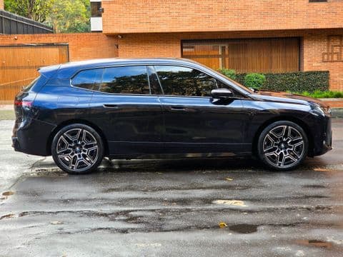 BMW IX XDRIVE45 2026 usado vista lateral azul oscuro estacionado en cochera