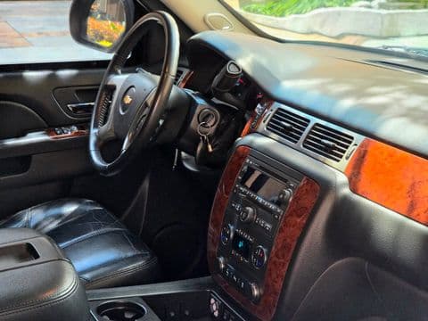 Chevrolet SUBURBAN 2012 usado interior tablero negro con detalles madera vista lateral