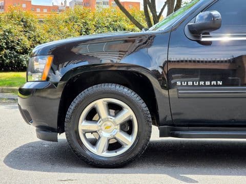 Chevrolet SUBURBAN 2012 usado vista lateral frontal color negro con llantas cromadas