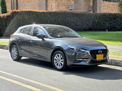 Mazda 3 2020 usado gris vista lateral completa frente a casa Bogotá